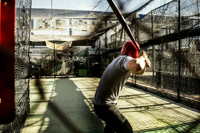 person holding baseball bat waiting for pitch